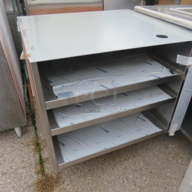 Stainless steel drink table with one door, three shelves, and protective covering, dimensions 37x35x37, in good condition.