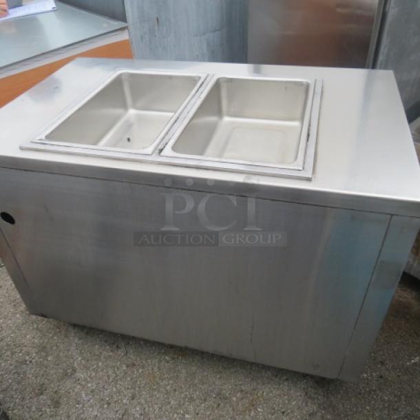 Stainless steel steam table with two wells and under shelf, 48x30x35 inches, used condition.