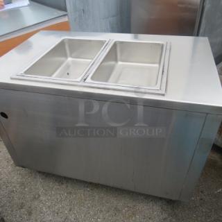 Stainless steel steam table with two wells and under shelf, 48x30x35 inches, used condition.