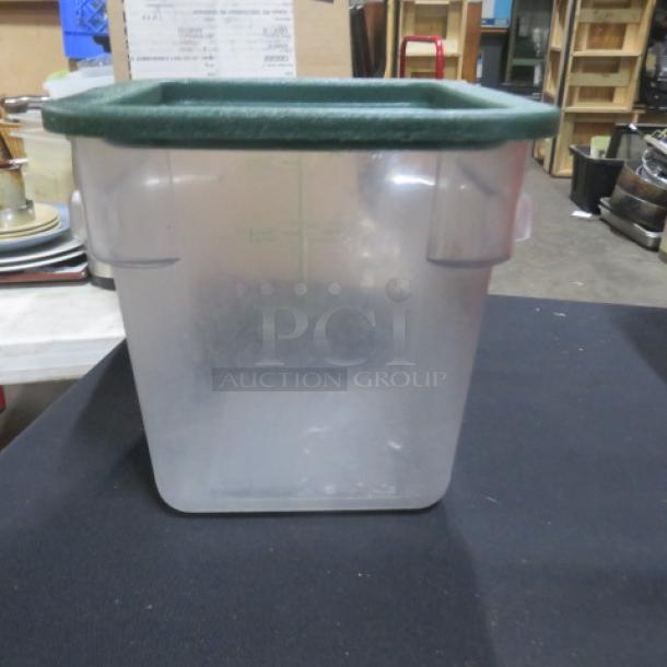 Clear 4-quart food storage container with green lid; used condition; square shape; suitable for kitchen or pantry storage.