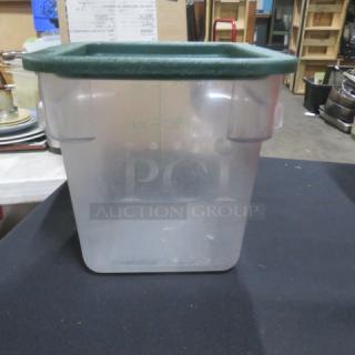 Clear 4-quart food storage container with green lid; used condition; square shape; suitable for kitchen or pantry storage.