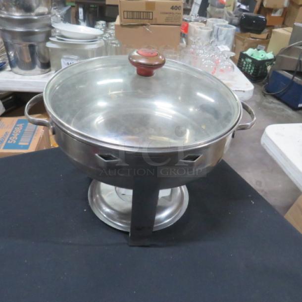 12-inch round stainless steel chafer with glass lid, featuring side handles and sturdy base. Appears in good condition.