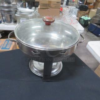12-inch round stainless steel chafer with glass lid, featuring side handles and sturdy base. Appears in good condition.
