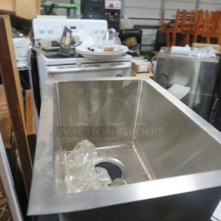 New stainless steel drop-in sink, 12x17x9 inches, pristine condition, with visible drain opening and protective wrapping.