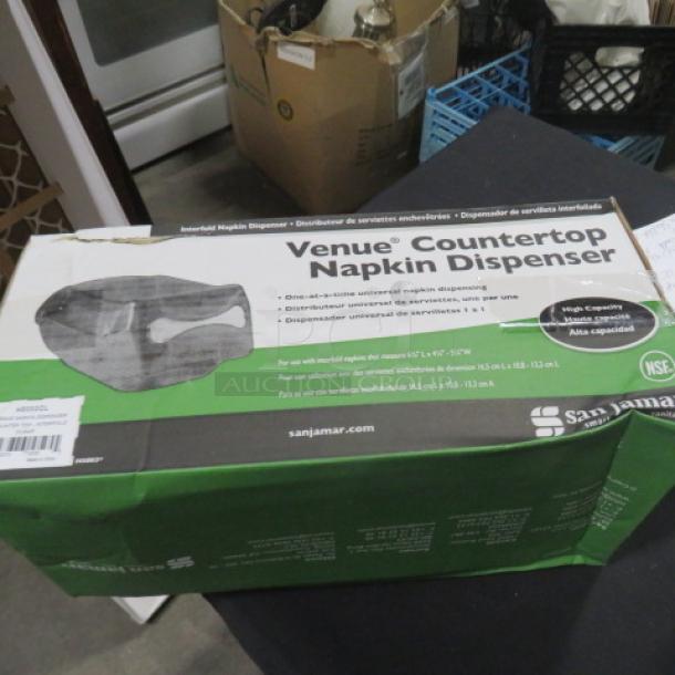 San Jamar Venue Countertop Napkin Dispenser, new in box. High capacity, NSF certified. Box shows product image and branding.