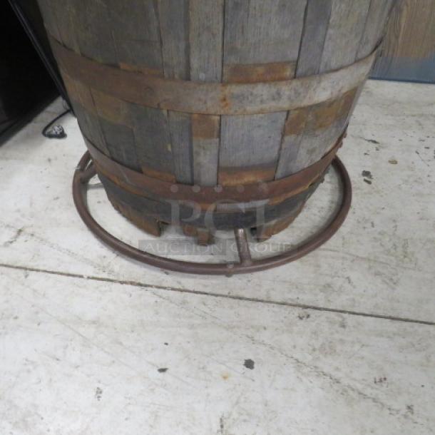 Wooden whiskey barrel with wooden top, 41x40 inches. Features visible metal bands and rustic patina, indicating age.