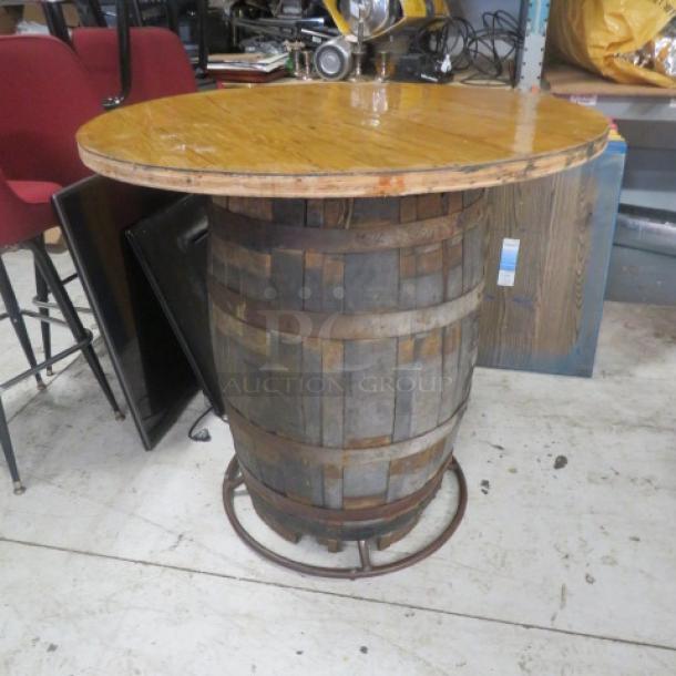 Wooden whiskey barrel table with wooden top, measures 41x40 inches. Rustic condition, metal hoops, ideal for home bar décor.