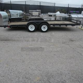 Ultra Tow 18-foot flatbed trailer, 5,000lb capacity, dual axles, white wheels. Appears in used condition.