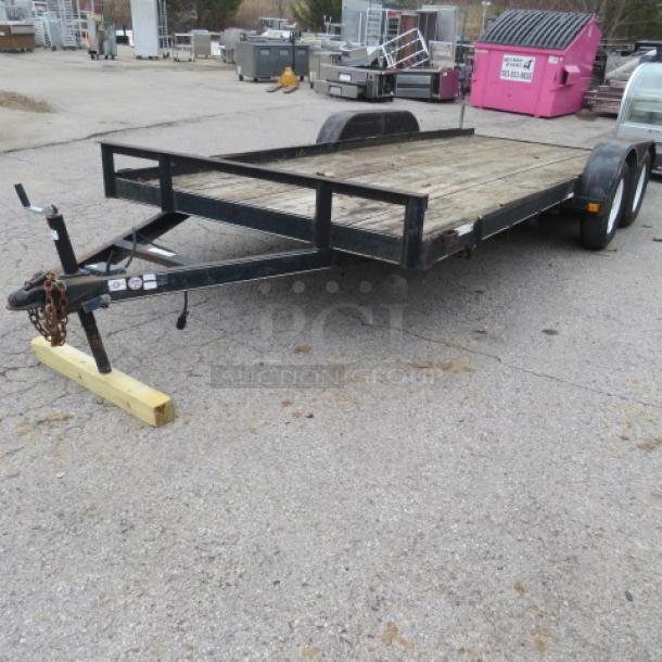 Ultra Tow 18 ft trailer, 5,000lb capacity, dual axle, metal frame, wooden deck. Used condition with visible wear.