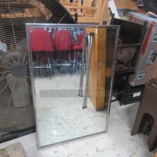 Stainless steel framed mirror, 24x36 inches, reflective surface, used condition.