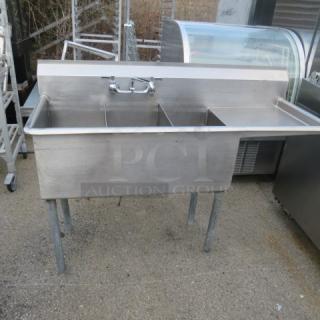 Stainless steel triple bowl sink with faucet and right-side drain board, 48x19x33 inches, in used condition.