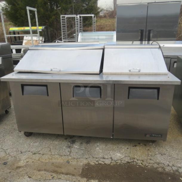 True TSSU-72-30M-B-ST refrigerated prep table, 3-door, on casters, stainless steel, 72x34x48 inches, working condition.