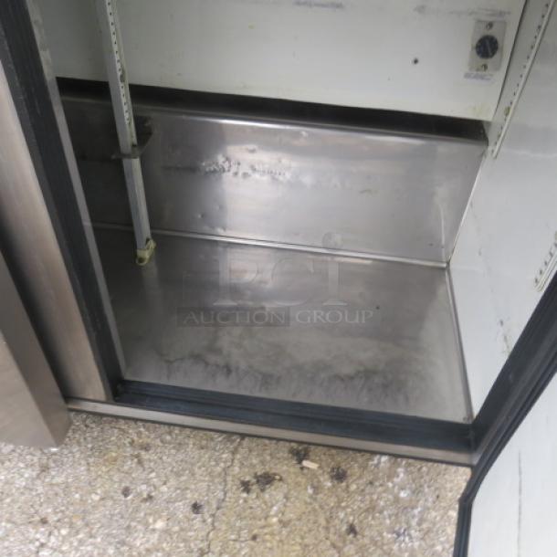 True TSSU-72-30M-B-ST 3-door refrigerated prep table, stainless interior, visible wear, 72x34x48 inches, on casters.