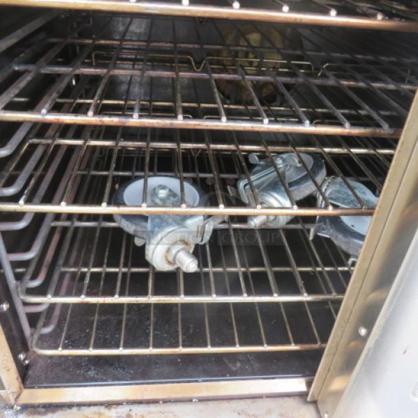 Elite EDCO-NG Double Convection Oven, natural gas, with 10 racks. Casters need reattachment. Dimensions 38x30.5x65.5 inches.