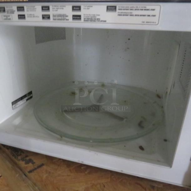GE Profile Microwave Model PEB2060SM1SS, 24x18x13.5 inches. Visible wear inside, 120 Volt, stainless steel. Model details shown.