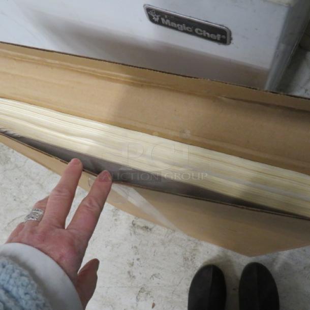 A box of new filter sheets, unopened. Contains multiple sheets, edges visible. Box on a concrete floor.