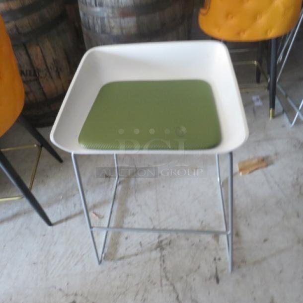 Metal bar stool with white molded seat, green cushion, and metal legs. Good condition, modern design.