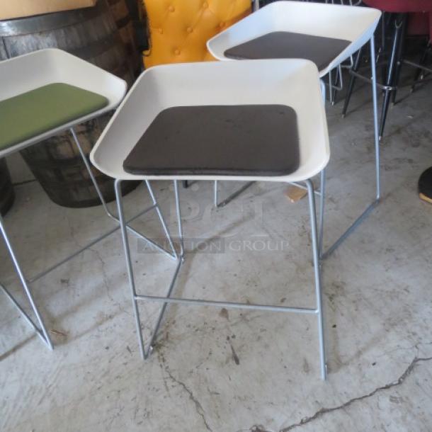 Metal bar stool with a white molded seat, brown cushion, metal legs. Good condition. Model: 2XBID.