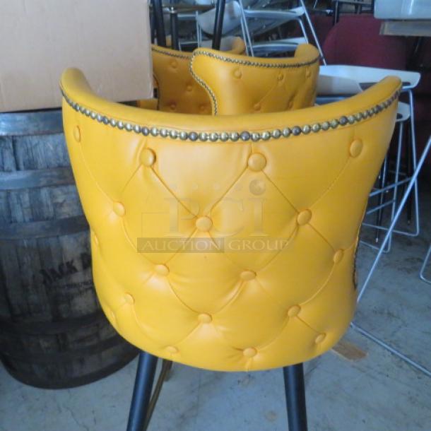Vintage bar stool with tufted yellow back, footrest, and nailhead trim. Good condition, sturdy design.