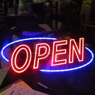 Illuminated LED "Open" sign in red and blue, 31x13 inches, in working condition, ideal for businesses.