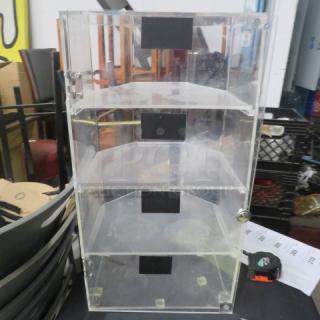 Acrylic pastry/bakery case with 1 door, 4 shelves, 13x12x24.5 inches. Needs pin for top hinge. Clear design, good condition.
