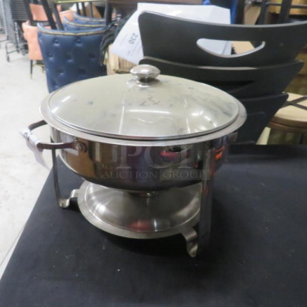 Stainless steel round chafer with lid, sturdy handles, and polished finish; ideal for catering and buffet settings.