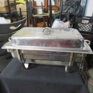 Stainless steel full-size chafer with lid, features dual handles and sturdy legs. Appears in used condition.