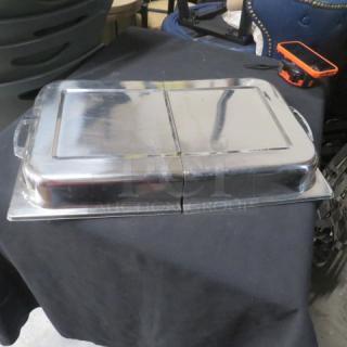 Stainless steel full-size hinged lid with handles, in good condition. Reflective surface with minor wear. Ideal for chafing dishes.