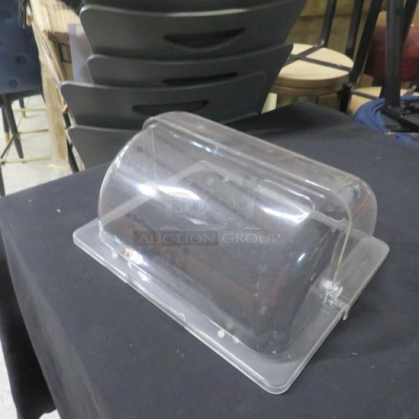 Clear acrylic roll top lid, half size, excellent condition, resting on a black table.