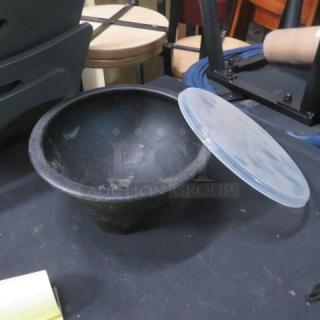 Molcajete 45oz bowl with plastic lid, item #P-03072. Used condition with visible wear on the interior. Black stone-like material.