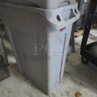 Rubbermaid Slim Jim trash can, gray, used condition, durable plastic, molded handles, visible dirt and scuff marks.