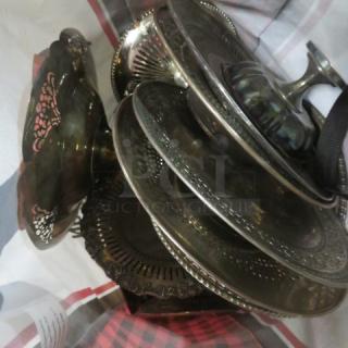 Assorted silver-plated serveware lot featuring trays and stands. Intricate patterns. Some tarnishing visible.