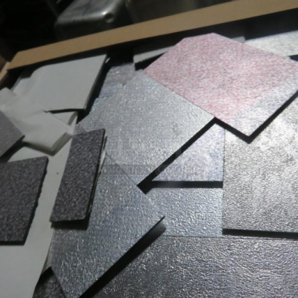 Assorted mosaic wall tiles in various textures and colors, including metallic and matte finishes, displayed in a box.