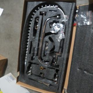 New dish faucet with sprayer, packaged in foam. Features chrome finish, modern design, and included installation components.