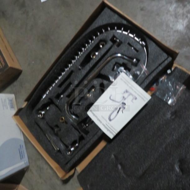 New dish faucet with sprayer in original packaging; parts organized in foam insert; installation manual visible.