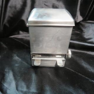 Stainless steel toothpick dispenser, new condition, sleek design with manual control knob, on black background.