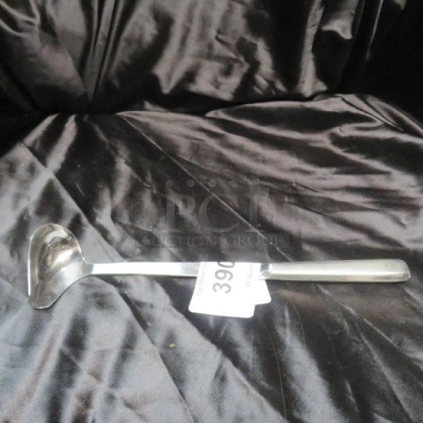 Stainless steel ladle with curved scoop, polished finish, label "390." Excellent condition, ideal for kitchen use.
