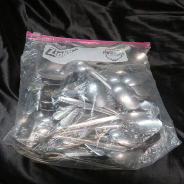 Bag of assorted metal spoons in good condition, stored in a clear Ziploc bag. Some spoons show mild wear.