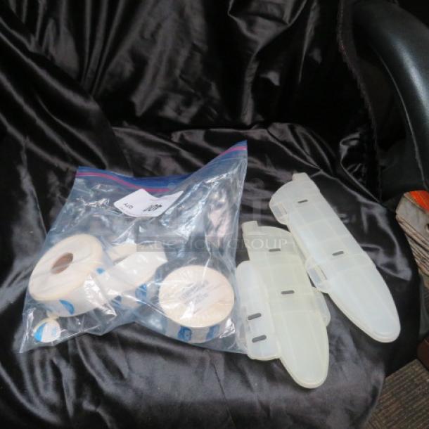 One lot of miscellaneous items including medical tapes and plastic splints in a clear zip bag, placed on a fabric surface.