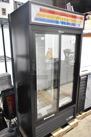 "Brand new True GDM-33-HC-LD 2-door cooler merchandiser with poly-coated racks, 115V, 1 phase, minor scratches visible."