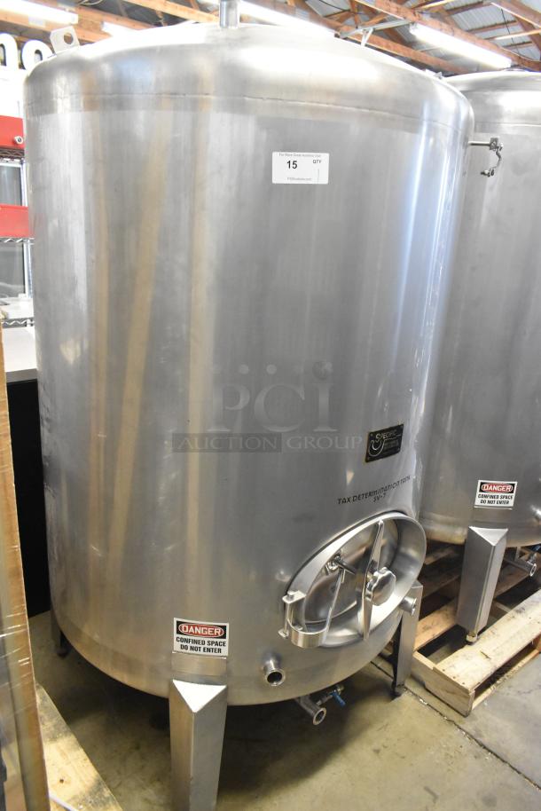 Stainless steel 10 BBL, 420-gallon beer tax determination tank with labels. Features cylindrical shape and sturdy legs.