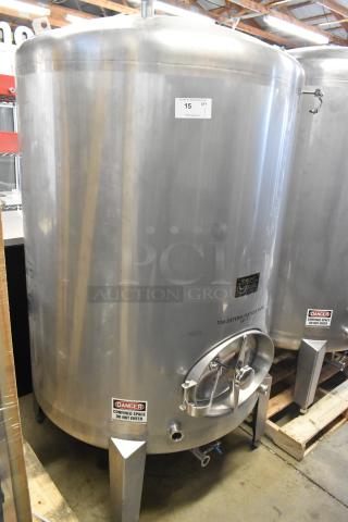 Stainless steel 10 BBL, 420-gallon beer tax determination tank with labels. Features cylindrical shape and sturdy legs.