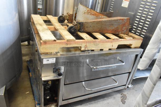 Bakers Pride stainless steel single deck pizza oven with metal legs on commercial casters. Visible wear, item tag "28 QTY 1".