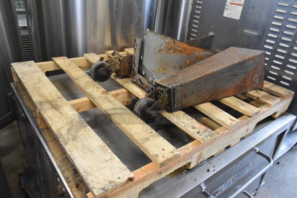 Bakers Pride commercial pizza oven metal legs on casters, showing rust, placed on a wooden pallet.