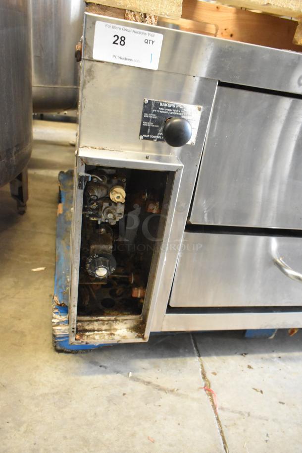 Bakers Pride stainless steel commercial single deck pizza oven with metal legs and commercial casters. Visible wear, control panel intact.
