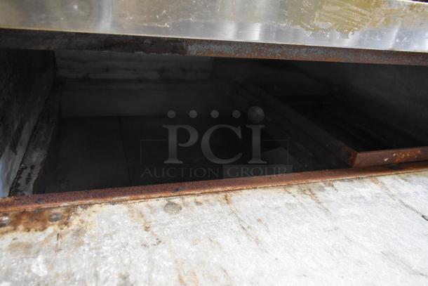 Bakers Pride stainless steel commercial single deck pizza oven interior, showing signs of use, with metal legs on commercial casters.