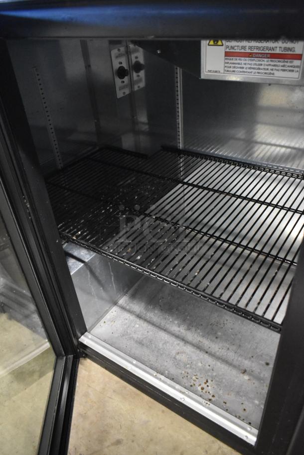 2023 True TBB-2G-HC-LD metal commercial cooler, black, 2 glass doors, shelves, 115 volts, visible internal wiring panel.