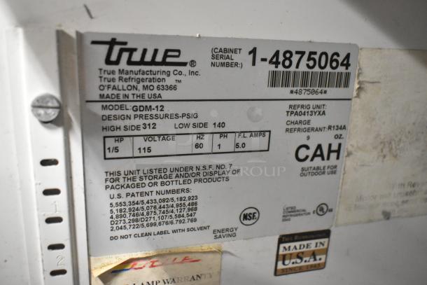 True GDM-12 cooler label showing model, voltage, phase, design pressures, and refrigerant details. Made in USA.