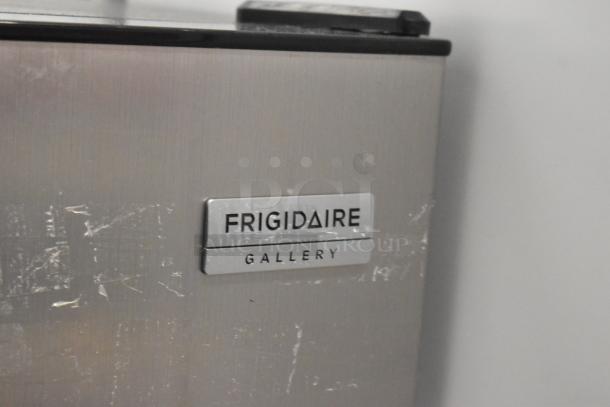 Frigidaire FGFR727 metal reach-in cooler with freezer, showing brand label. 115 volts, 1 phase. Visible wear on surface.