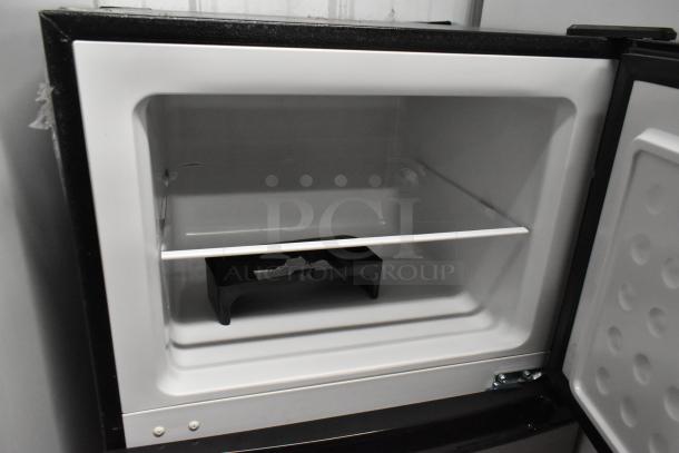 Frigidaire FGFR727 metal reach-in cooler with freezer, 115 volts, 1 phase, open door, showing interior shelving.